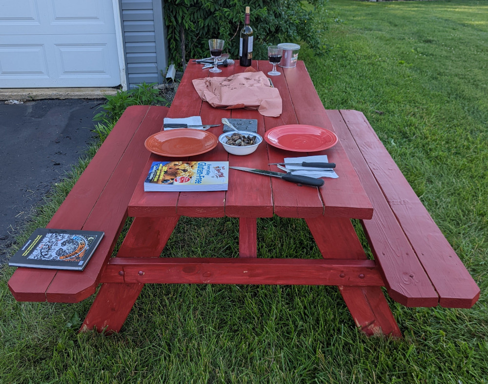 The finished bench stained red and set for dinner